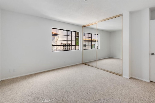 unfurnished bedroom featuring a closet, carpet flooring, and baseboards