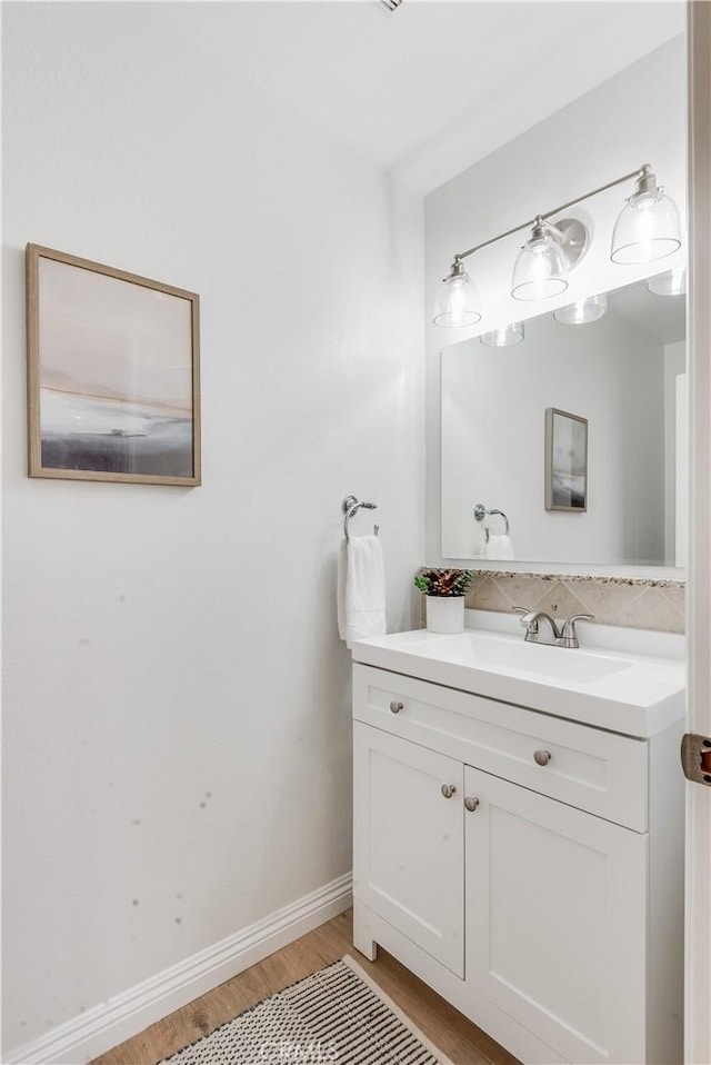 bathroom featuring vanity, baseboards, and wood finished floors