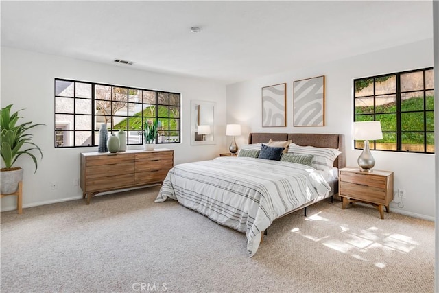 bedroom with carpet floors, visible vents, and baseboards