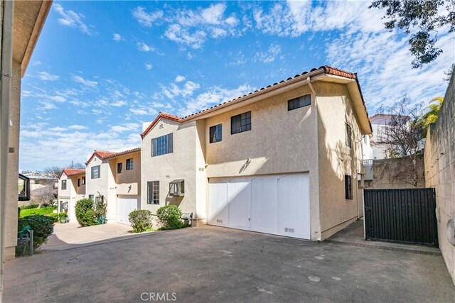 2008 Mathews Ave Unit C, Redondo Beach, CA 90278 - view of front of property with stucco siding, driveway, a residential view, a tile roof, and an attached garage
