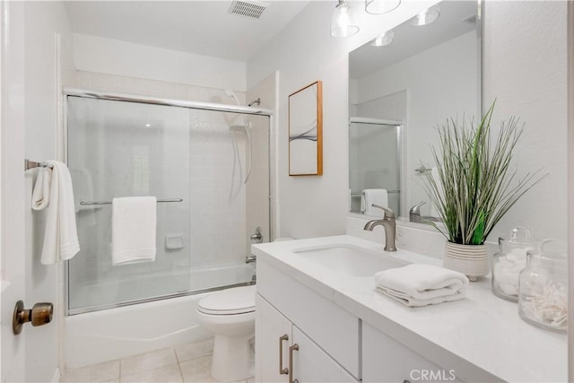 bathroom featuring shower / bath combination with glass door, visible vents, toilet, vanity, and tile patterned floors