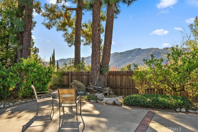 view of patio featuring a mountain view and fence