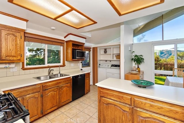 kitchen featuring a sink, stainless steel microwave, range with gas stovetop, black dishwasher, and separate washer and dryer