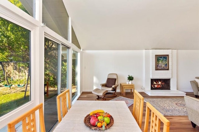 sunroom with a large fireplace and lofted ceiling