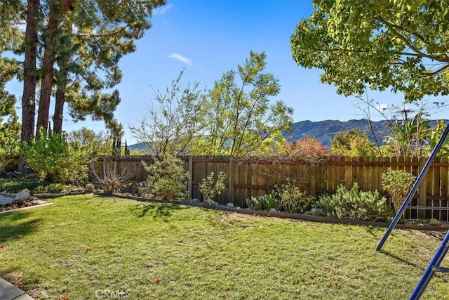 view of yard featuring a mountain view and a fenced backyard