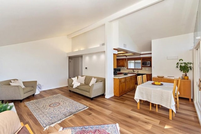 living area with visible vents, light wood-type flooring, and baseboards