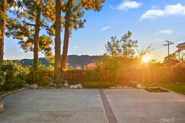 view of patio with a mountain view and fence