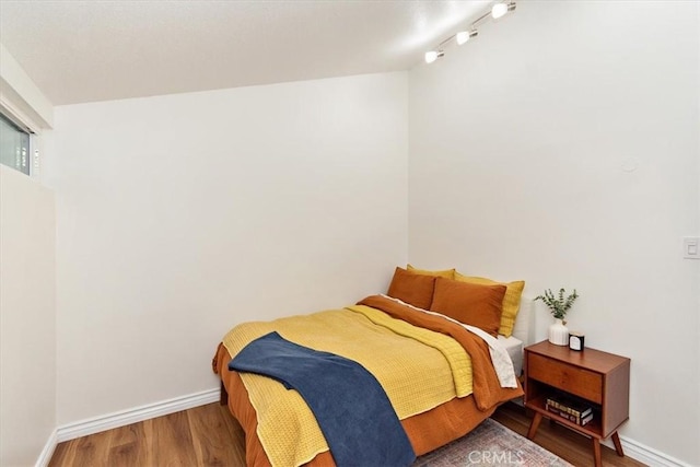 bedroom with baseboards and wood finished floors