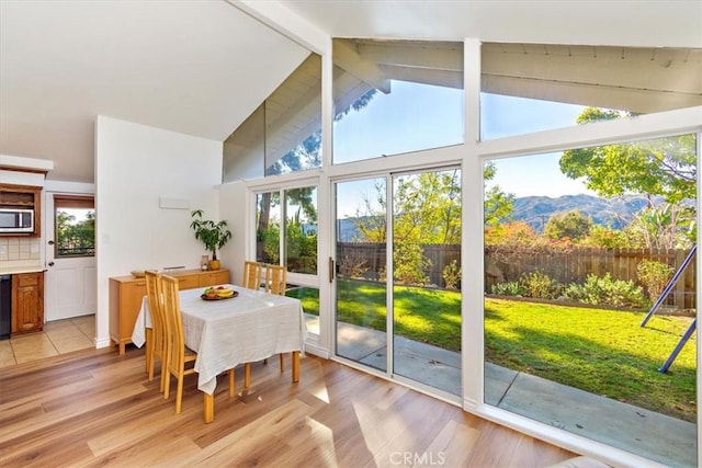 sunroom with a mountain view and vaulted ceiling with beams