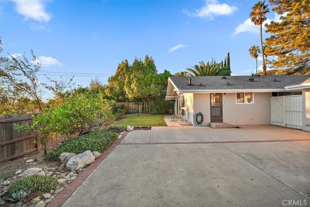 rear view of property with stucco siding, fence private yard, and a patio area