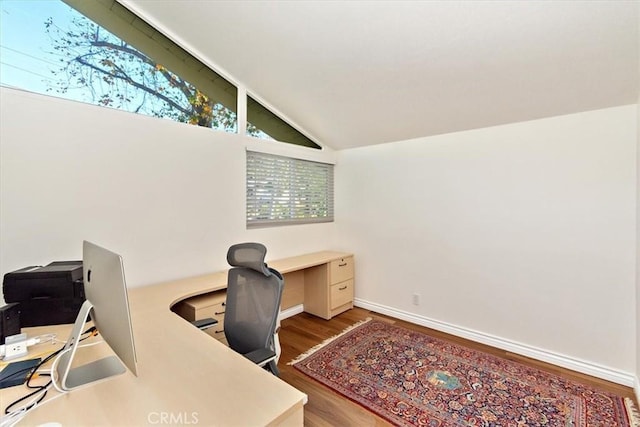 office area featuring baseboards, wood finished floors, and vaulted ceiling