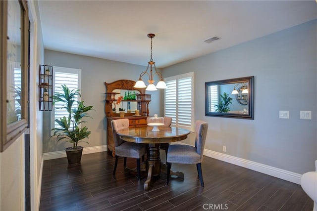 dining space with a notable chandelier, dark wood-style flooring, visible vents, and baseboards