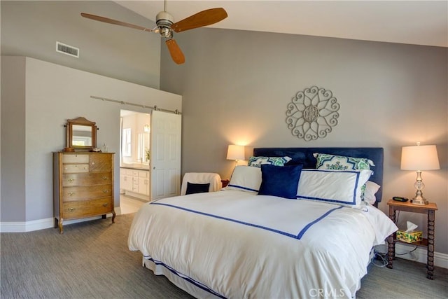 bedroom featuring visible vents, a barn door, carpet flooring, connected bathroom, and baseboards