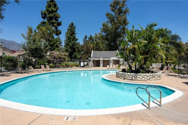 pool with a patio and fence