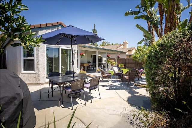 view of patio featuring outdoor dining space and fence