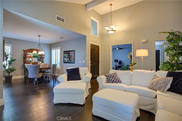 living area featuring baseboards, visible vents, dark wood-type flooring, a chandelier, and beam ceiling