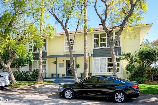 view of property featuring a chimney and stucco siding