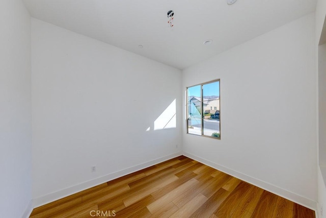 empty room featuring light wood-style floors and baseboards