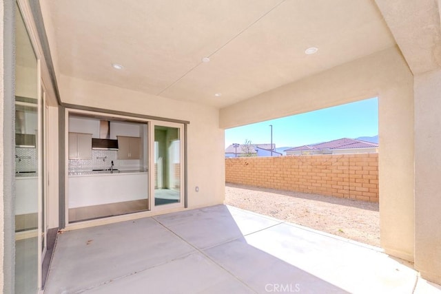 view of patio with a sink and fence