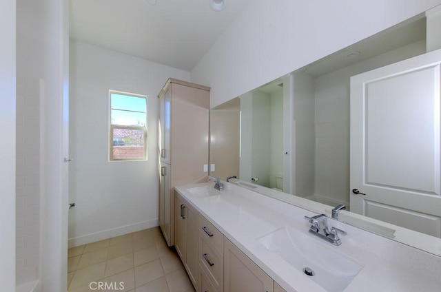 full bath featuring double vanity, baseboards, and a sink