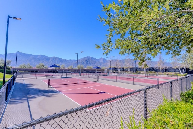 view of sport court with fence and a mountain view