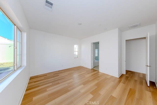 spare room with light wood-style floors and visible vents