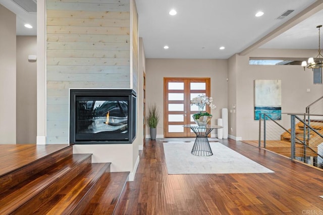 living room with visible vents, stairs, wood finished floors, baseboards, and recessed lighting
