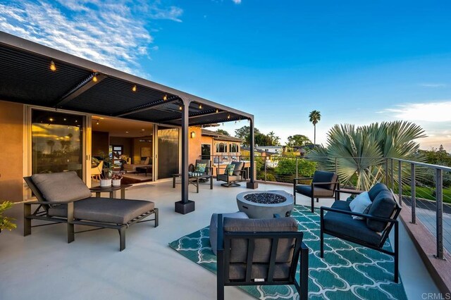 view of patio / terrace featuring an outdoor living space with a fire pit and a balcony