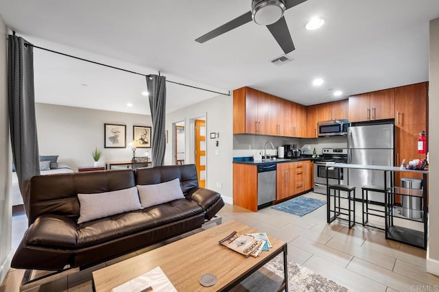 living room with baseboards, a ceiling fan, recessed lighting, and visible vents