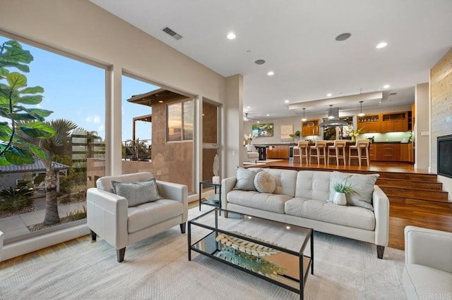 living area with visible vents, recessed lighting, and light wood-style flooring