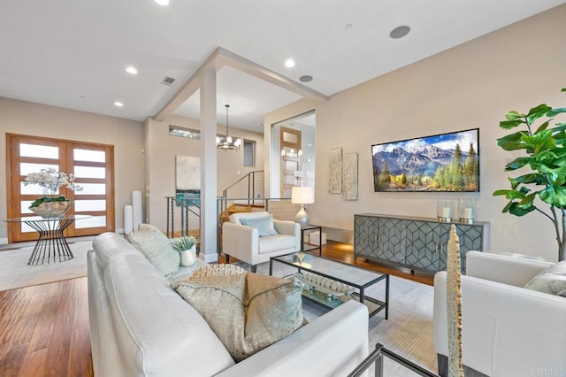 living area featuring visible vents, wood-type flooring, recessed lighting, and a notable chandelier