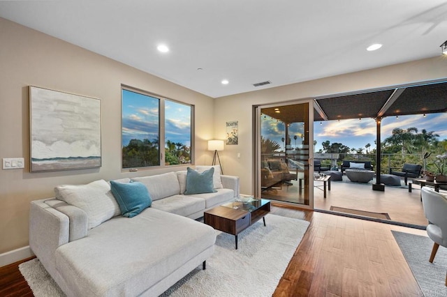 living area with visible vents, recessed lighting, baseboards, and wood finished floors