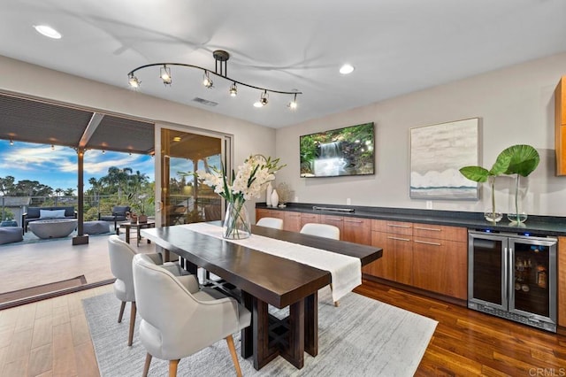 dining space with wood finished floors, recessed lighting, beverage cooler, and visible vents