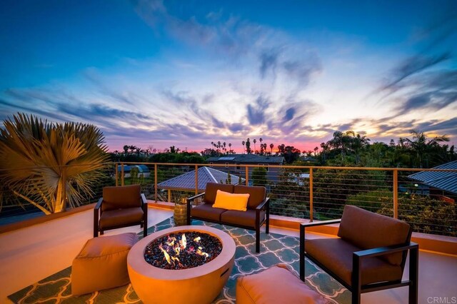 exterior space with an outdoor living space with a fire pit and a balcony