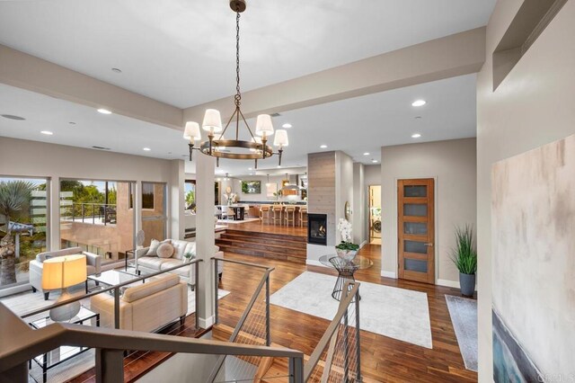 dining space with an inviting chandelier, recessed lighting, wood finished floors, and a fireplace