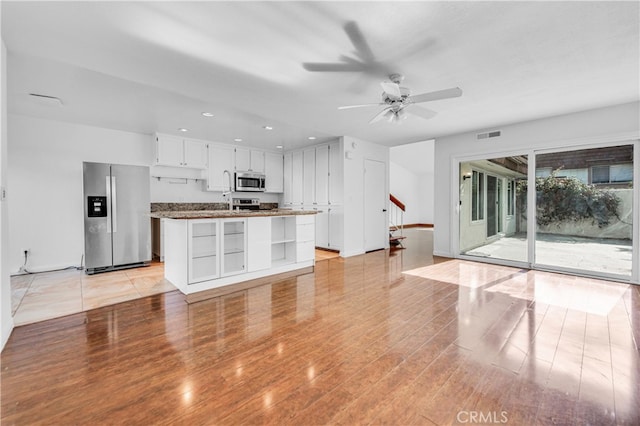 kitchen featuring light wood-type flooring, white cabinetry, appliances with stainless steel finishes, and a ceiling fan