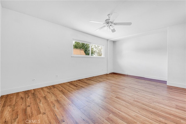 unfurnished room featuring baseboards, a ceiling fan, and light wood-style floors