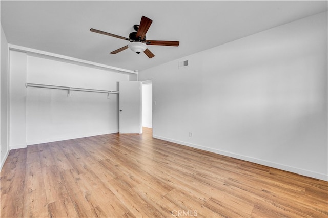 unfurnished bedroom featuring wood finished floors, a ceiling fan, visible vents, baseboards, and a closet