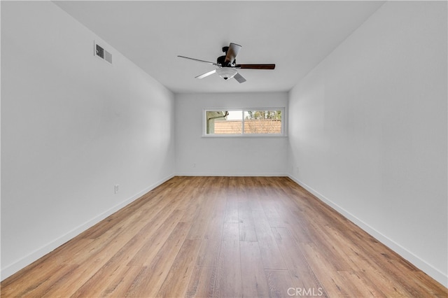 unfurnished room featuring light wood finished floors, a ceiling fan, visible vents, and baseboards