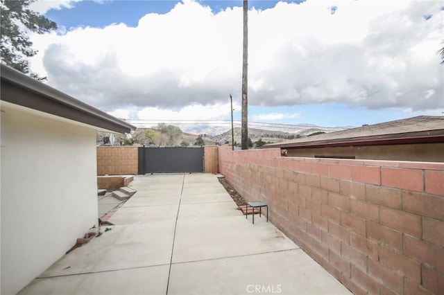 view of side of home with a patio area, fence, and stucco siding