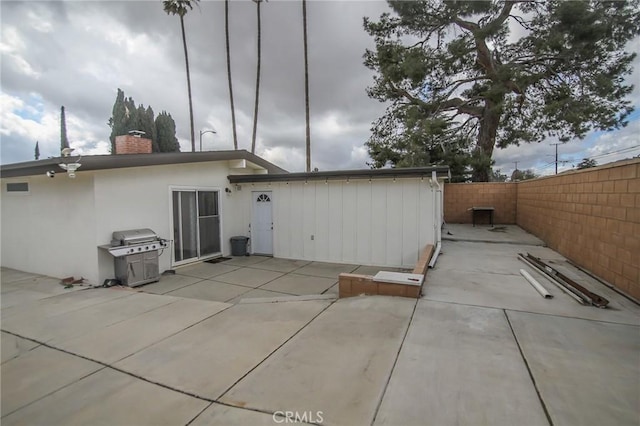 back of property featuring stucco siding, a fenced backyard, a chimney, and a patio