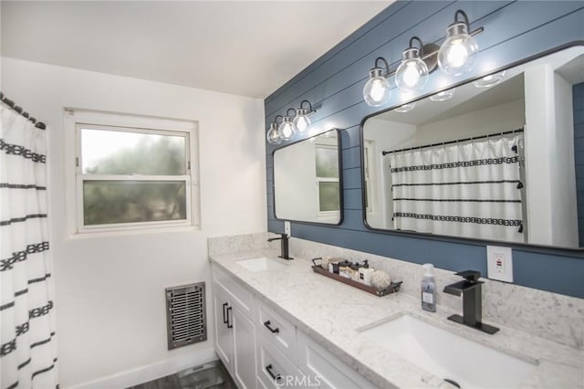 full bathroom featuring double vanity, visible vents, and a sink