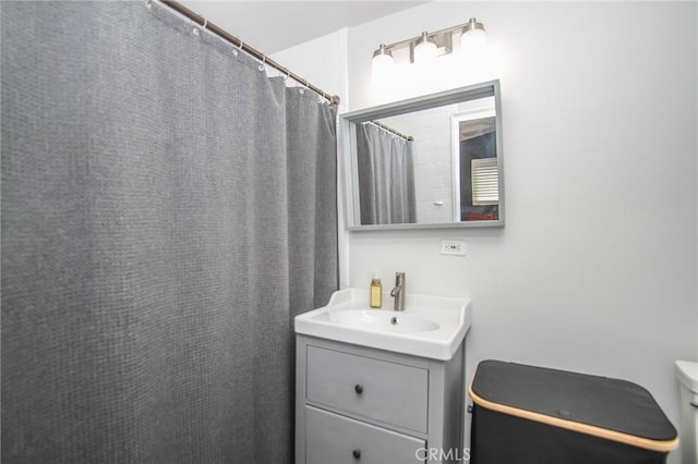 full bathroom featuring curtained shower, vanity, and toilet