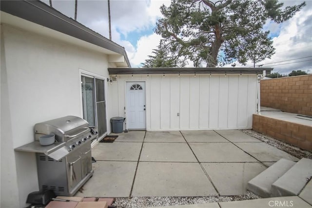 view of patio with area for grilling and fence