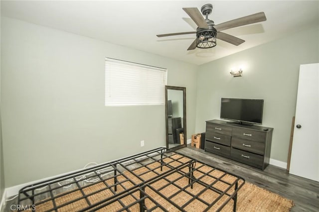 bedroom featuring dark wood-style floors, a ceiling fan, and baseboards