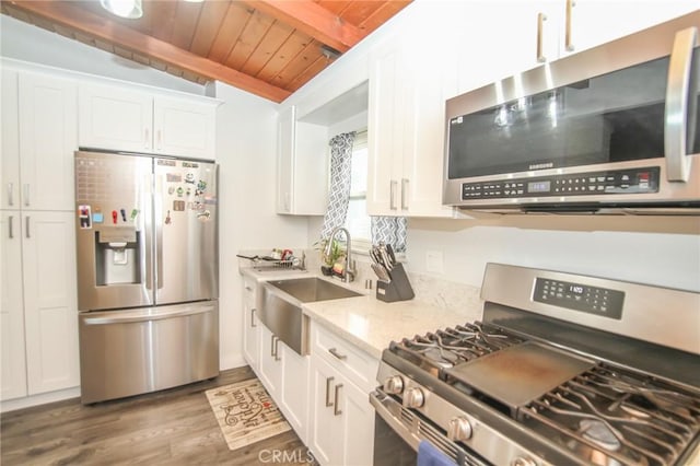 kitchen with wooden ceiling, wood finished floors, a sink, white cabinetry, and appliances with stainless steel finishes