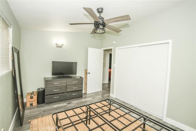 bedroom with a closet, baseboards, and wood finished floors