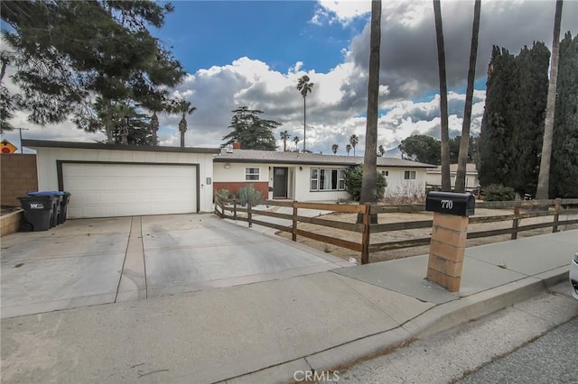 ranch-style house with a garage, driveway, and a fenced front yard