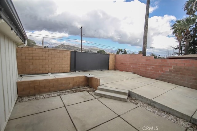 view of patio / terrace with fence and a mountain view