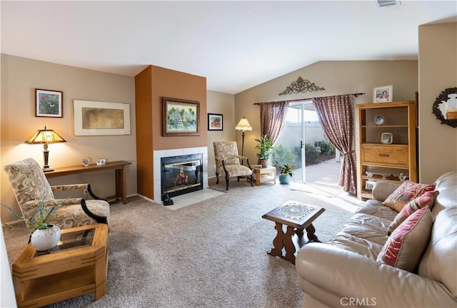 carpeted living room featuring lofted ceiling, a tiled fireplace, and visible vents